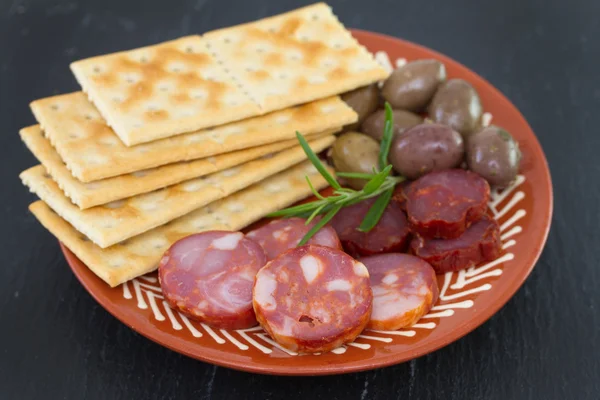 Chourico with olives on dish — Stock Photo, Image