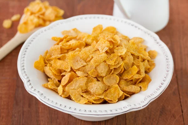 Hojuelas de maíz en plato blanco — Foto de Stock