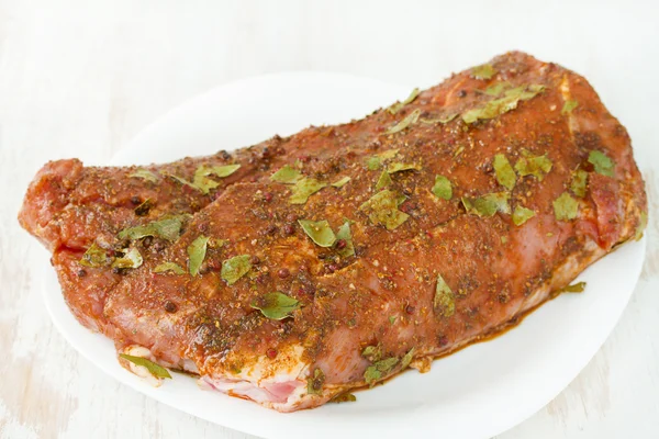 Raw pork with pepper on white dish — Stock Photo, Image