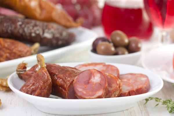 Chourico auf weißem Teller mit Wein und Oliven — Stockfoto