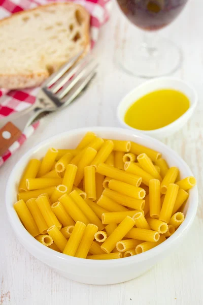 Pasta in bowl with bread and oil