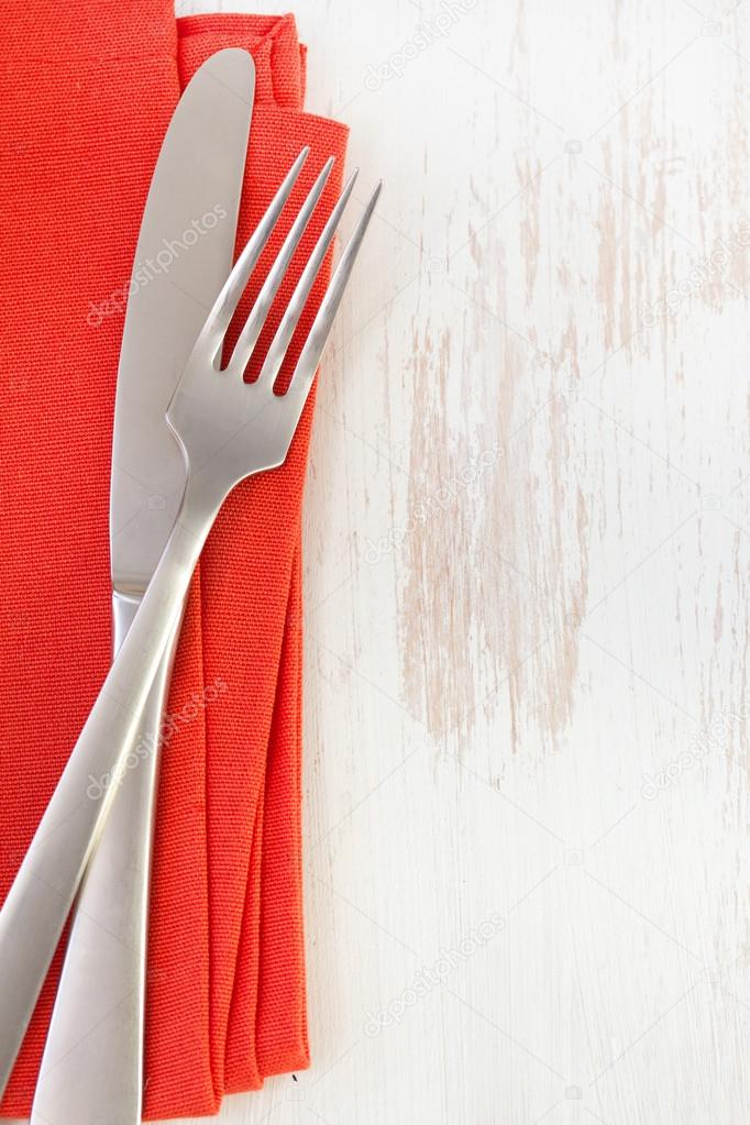 Napkin with knife and fork on white background