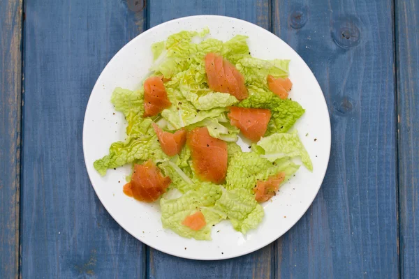 Salat mit Räucherlachs auf weißem Teller — Stockfoto