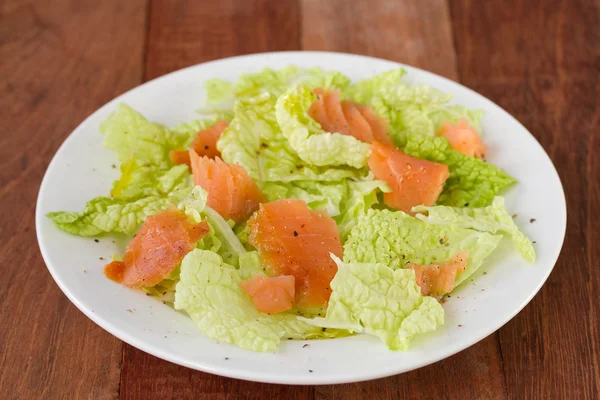 Salat mit Räucherlachs auf weißem Teller — Stockfoto