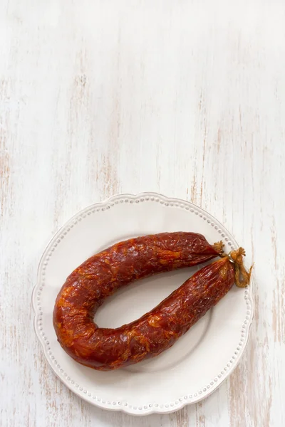 Smoked sausage on white plate — Stock Photo, Image