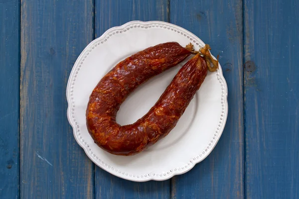 Smoked sausage on white plate — Stock Photo, Image