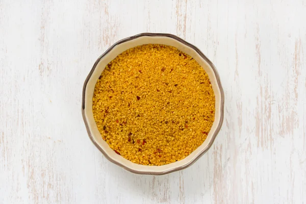Couscous in dish on brown background — Stock Photo, Image