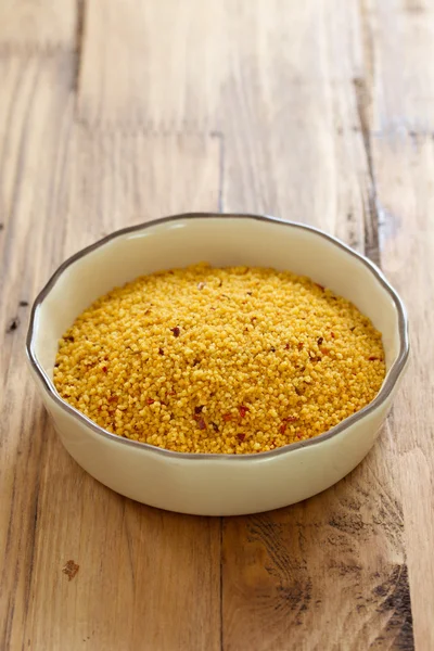 Couscous in der Schale auf braunem Hintergrund — Stockfoto