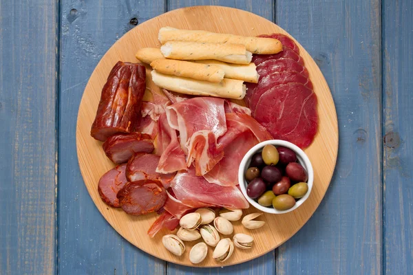 Apéritif de viande avec olives et noix sur le plateau — Photo