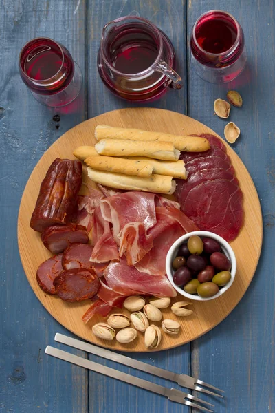 Meat appetizer with olives and nuts on tray — Stock Photo, Image