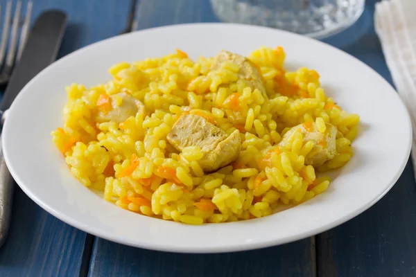 Riso con carne e carota su piatto e bicchiere d'acqua — Foto Stock