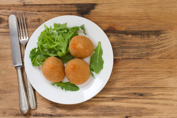 Meat croquette on white plate on brown wooden background — Stock Photo, Image