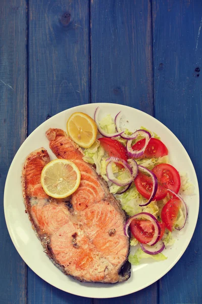야채 샐러드와 레몬 화이트 접시에 튀긴 연어 — 스톡 사진