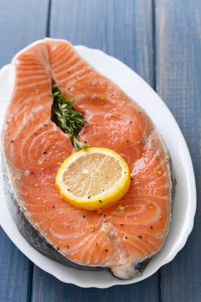 Fresh salmon with lemon on white dish — Stock Photo, Image