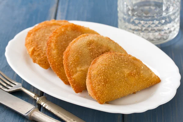 Biscoitos de carne portugueses, rissois em prato branco sobre fundo azul — Fotografia de Stock