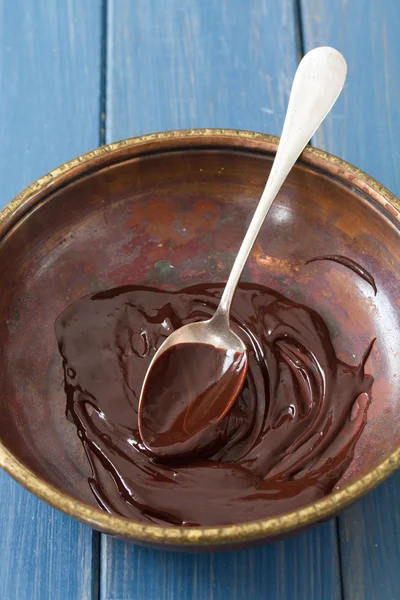 Chocolate em prato com colher em fundo de madeira azul — Fotografia de Stock