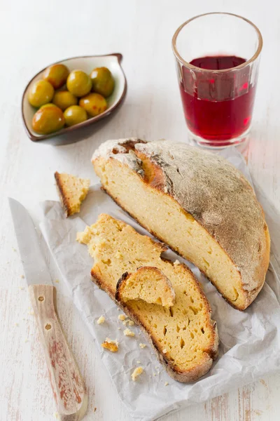 Maisbrot mit Oliven und Rotwein auf Papier — Stockfoto