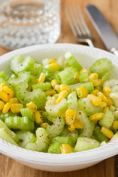 Ensalada de apio con maíz en tazón blanco sobre fondo de madera marrón — Foto de Stock