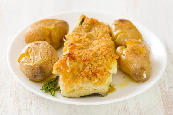 Fried fish with potato and oil on dish — Stock Photo, Image