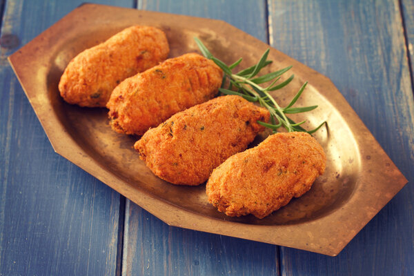 cod fish croquettes on dish on blue background