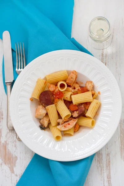 Pasta with dry tomato and smoked sausages on plate — Stock Photo, Image