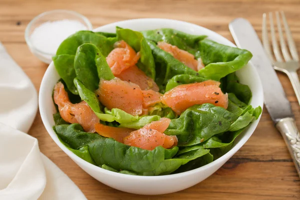 Salat mit geräuchertem Fisch auf weißer Schüssel — Stockfoto