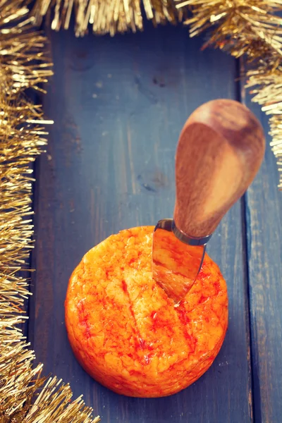 Spicy cheese with knife on blue wooden background — Stock Photo, Image