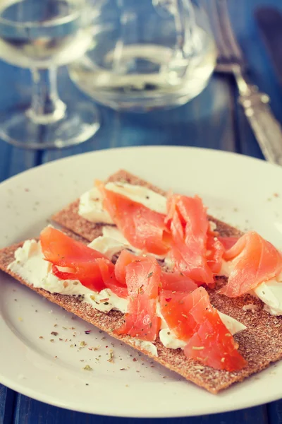 Beyaz plaka üzerinde füme balık ile tost — Stok fotoğraf