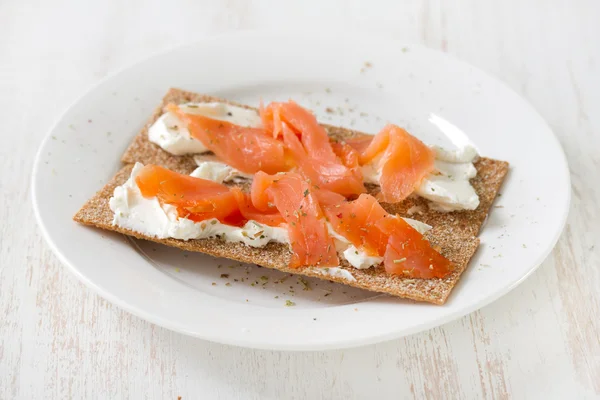 Beyaz plaka üzerinde füme balık ile tost — Stok fotoğraf