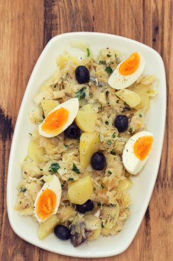 Beyaz çanak üzerinde sebze ve zeytin ile balık