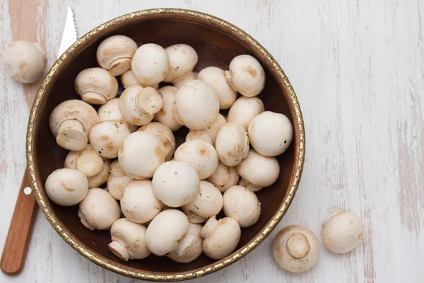 Beyaz ahşap zemin üzerinde kase mantar