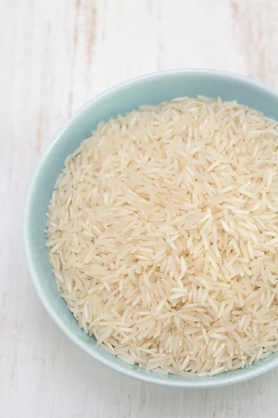 Arroz crudo en tazón azul —  Fotos de Stock