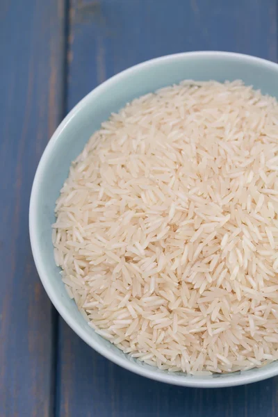 Arroz crudo en tazón azul —  Fotos de Stock