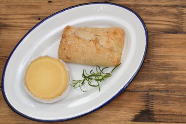 Beyaz tabak kahverengi ahşap zemin üzerinde ekmek ile peynir