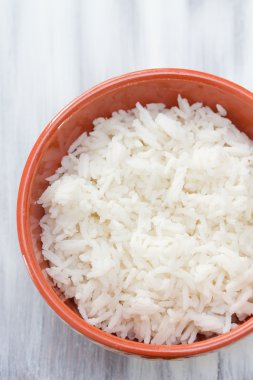 Mavi ahşap arka plan üzerinde kahverengi seramik tabak haşlanmış pirinç