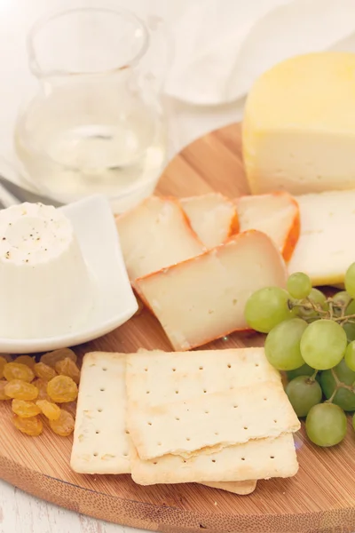 Queijo com biscoitos, uvas e vinho branco — Fotografia de Stock