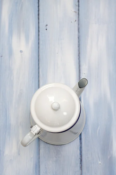 Panela de chá branco no fundo de madeira azul — Fotografia de Stock