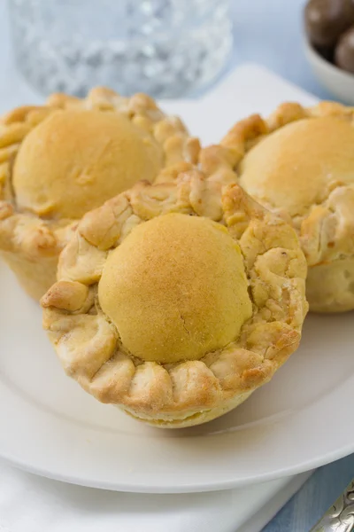 Pie with chicken on white plate on blue background — Stock Photo, Image