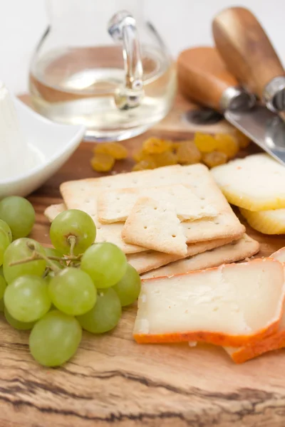 Queijo com biscoitos, uvas e vinho branco — Fotografia de Stock