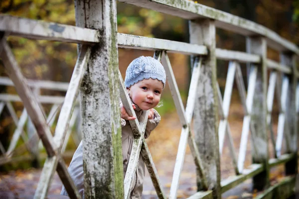 Meisje op houten brug buitenshuis — Stockfoto