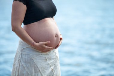 eller göbek üzerinde tutan kadın