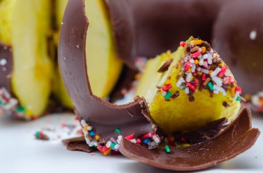 Elma şekeri parçacıkları. Sütlü çikolatayla kaplanmış. Renkli şeker parçacıkları, şekerleme.