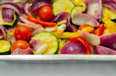 Kırmızı soğan, kabak, kiraz domatesleri, kırmızı biber ve sarı biber, kolza yağı ve fesleğen sosu, Akdeniz sebzeleri.