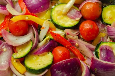 Kırmızı soğan, kabak, kiraz domatesleri, kırmızı biber ve sarı biber, kolza yağı ve fesleğen sosu, Akdeniz sebzeleri.