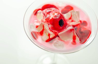 Votka, krema likörü ve göz şeklinde yenilebilir dekoratif bir maddeye dayanan bir martini bardağında Cadılar Bayramı içkisi. Korkunç bir kokteyl.