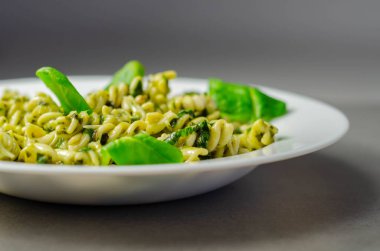 Pesto ve çam fıstıklı makarna salatası, regato peynirli fusilli makarna ve fesleğen soslu bebek ıspanağı, İtalyan yemeği.