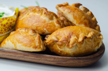 Ekşi kremalı mini börekler, leziz domuz eti, hindi, domuz pastırması ve yaban mersini, hepsi kıtır hamura sarılmış, lezzetli yiyecekler.