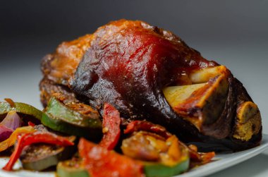 Izgara sebzeler, kırmızı ve sarı biberler, kabak ve kırmızı soğan ve taverna ile servis edilen domuz eti lokantası.