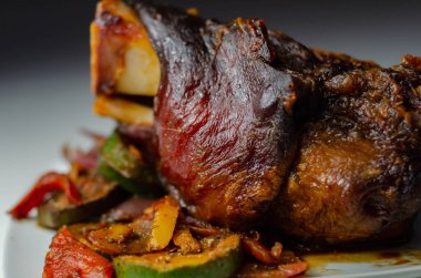 Izgara sebzeler, kırmızı ve sarı biberler, kabak ve kırmızı soğan ve taverna ile servis edilen domuz eti lokantası.