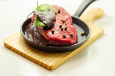 Kızartma, özel ve pahalı et için küçük bir tavada baharatlı çiğ biftek fileto.